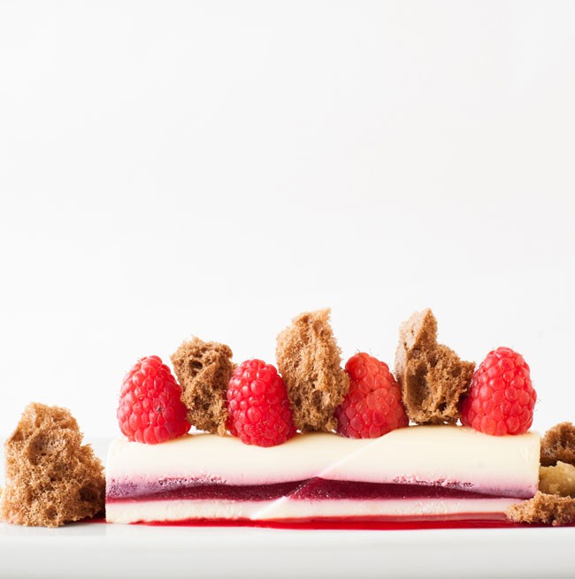 Photo of a delicious layered dessert with raspberries