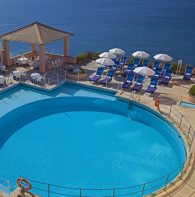 Tagesfoto des runden Swimmingpools mit Blick auf das Meer des Hotels Punta San Martino