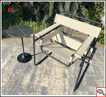 Outdoor Tulip Table Coffee table with Desir Noir ceramic top beside an Outdoor Wassily canvas chair.