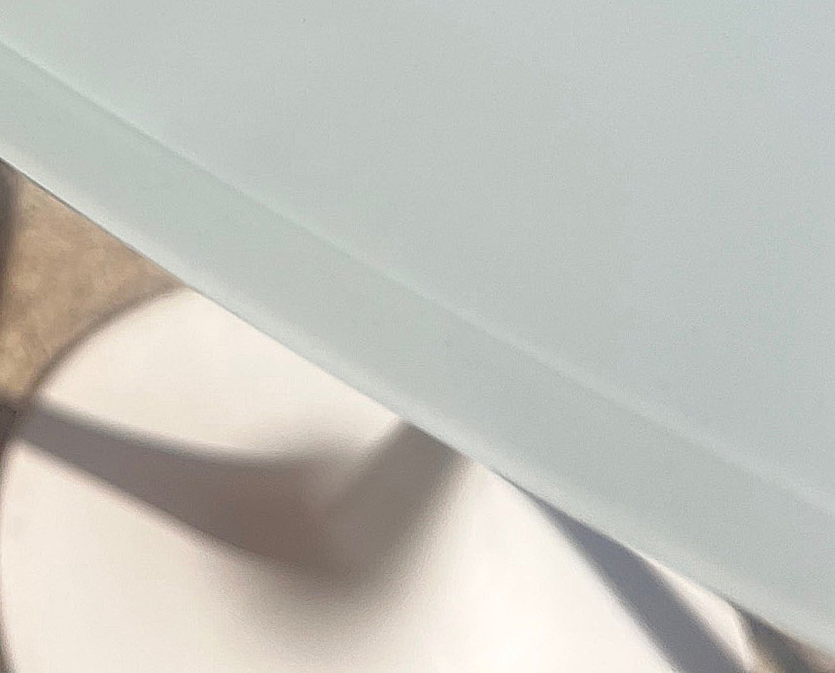 Dettaglio bordo Tavolo Tulip con piano in vetro bianco extrachiaro.